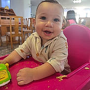 Imran a rejoint le concours — aidez-le/la à gagner de superbes lots ! baby, child, high_chair, smile, toy, crumbs, indoor, dining_room, wooden_chairs, table, person, clothing, cute, happy, face, infant, seat, playful, toddler, light