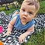 baby, blanket, blue_eyes, child, curious, cute, daylight, face, grass, hands, infant, nature, outdoor, pattern, person, playing, portrait, sleeveless, stroller, toy