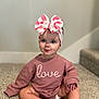 baby, child, sitting, carpet, pink_sweatshirt, headband, bow, indoor, stairs, cute, portrait, young_child, clothing, floor, person, blue_eyes, expression, skin, long_sleeves, infant