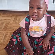 Marlène participe au concours pour gagner de l'argent avec cette photo : child, toddler, girl, dress, headwrap, pink, patterned_clothing, floor, wood_floor, sitting, indoor, furniture, table, couch, footwear, shoe, person, cute, portrait, living_room