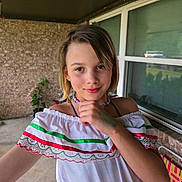 Ada-grace joined the competition — help win amazing prizes! child, girl, portrait, smile, dress, white_dress, necklace, bracelet, outdoor, porch, brick_wall, window, plant, hand_on_chin, short_hair, happy, young, casual, colorful, person