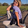 Ada-grace is registered to the contest to win money with this photo: child, glasses, smiling, outdoor, daylight, grass, sky, tshirt, leggings, pedestal, hand, pose, happy, park, railing, casual, blonde_hair, nature, sunlight, young
