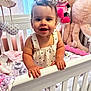 Alaiah is registered to the contest to win money with this photo: baby, crib, toy, stuffed_animal, minnie_mouse, octopus, smile, child, nursery, blanket, clothing, hand, face, person, furniture, indoor, curtain, window, pink, white