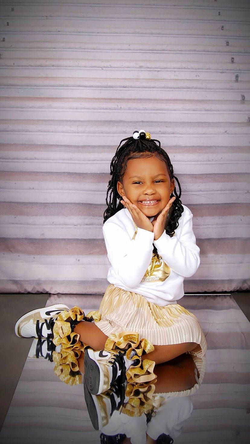 Amoura Rogers is registered to the contest to win money with this photo: audio_equipment, black_hair, child, costume, eyewear, fashion_accessory, fashion_design, flash_photography, formal_wear, fun, happy, human_leg, jewellery, joy, knee, person, sitting, sleeve, smile, thigh