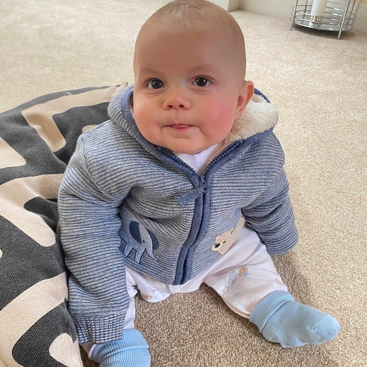 Joseph is registered to the contest to win money with this photo: baby, candle, clothing, coat, crawling, face, head, hoodie, hosiery, jacket, jeans, knitwear, pants, person, photography, portrait, sitting, sock, sweater, sweatshirt