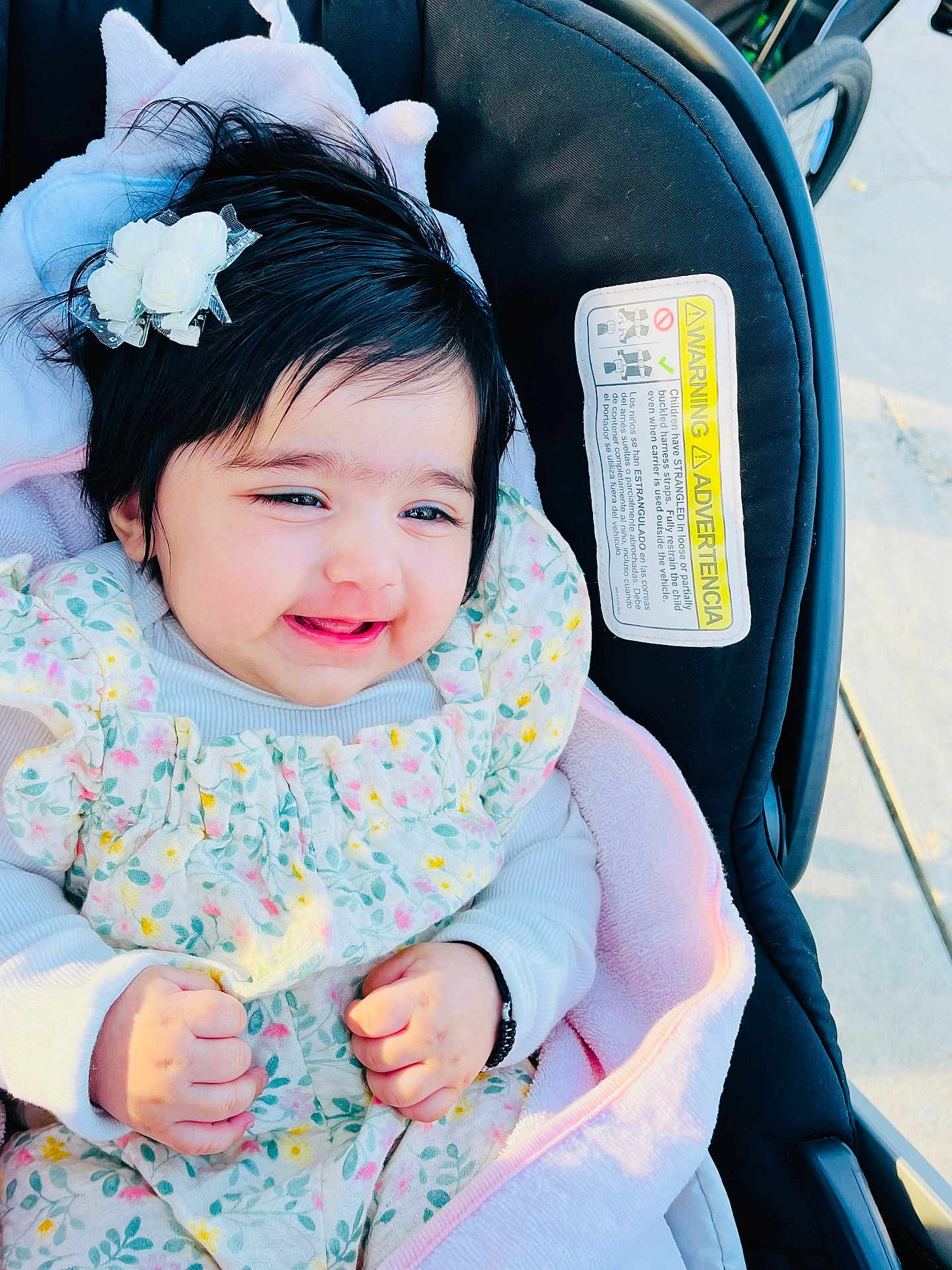 Tripat Kaur Cheema is registered to the contest to win money with this photo: baby, child, smiling, flower_hair_clip, floral_dress, blanket, stroller, hands, face, happy, outdoor, person, cute, infant, clothing, head, skin, photography, portrait, young