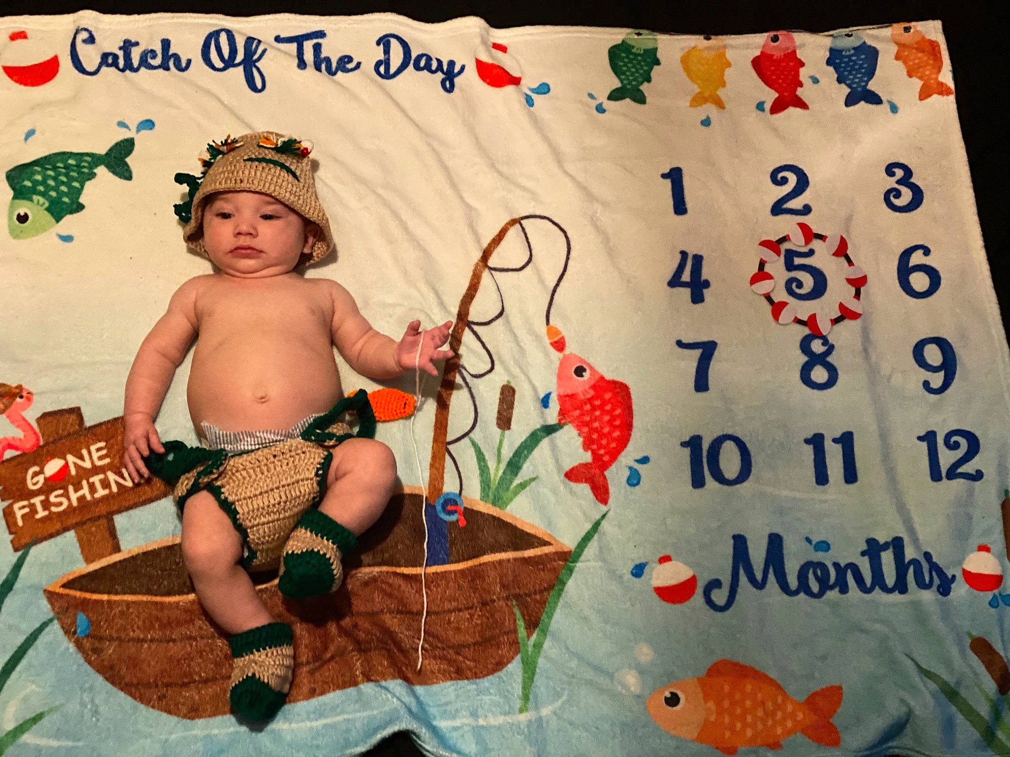 Brentlee is registered to the contest to win money with this photo: art, baby, baby_products, child, diaper, event, fictional_character, font, grass, happy, headwear, illustration, linens, pattern, person, photo_caption, product, sandal, sitting, thigh
