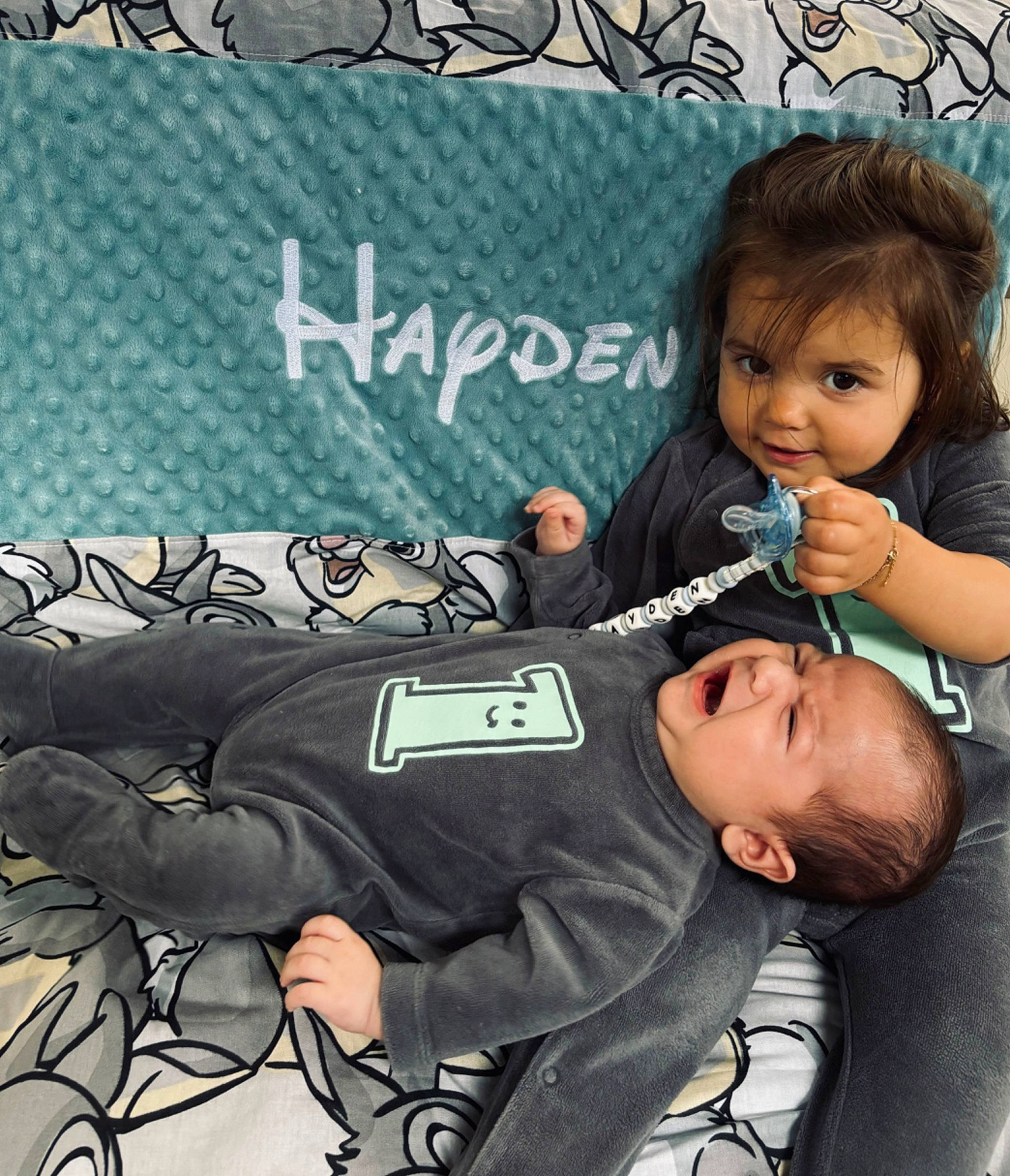 Hayden participe au concours pour gagner de l'argent avec cette photo : baby, baby_products, baby_toddler_clothing, black_hair, child, comfort, eyelash, font, happy, pattern, person, photo_caption, room, sitting, sleeve, t_shirt, toddler