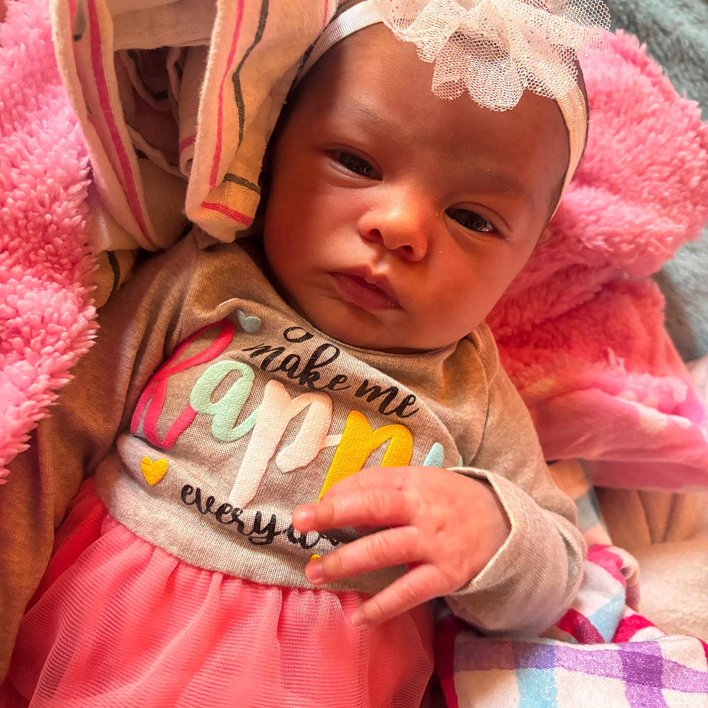 Jaelani is registered to the contest to win money with this photo: baby, infant, headband, pink_tutu, blanket, soft_fabric, clothing, cute, child, portrait, indoor, colorful, hand, face, newborn, cozy, warm, expression, laying, toddler