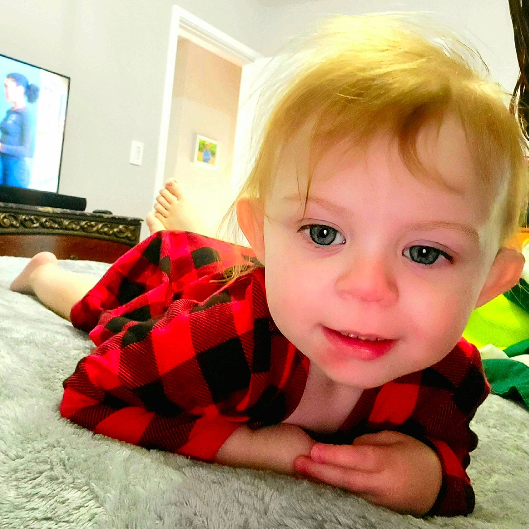 Izayah is registered to the contest to win money with this photo: baby, baby_toddler_clothing, blurred, comfort, finger, flooring, gadget, happy, home_appliance, human_body, mouth, pattern, person, plaid, room, selfie, sitting, sleeve, smile, tartan