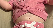 Kennedy is registered to the contest to win money with this photo: baby, infant, smiling, pink_clothing, shorts, tshirt, lying_down, bed, happy, cute, child, human, skin, face, legs, arms, diaper, expression, indoors, soft_lighting