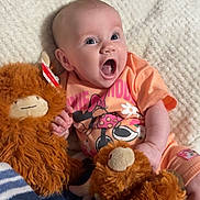 Kennedy joined the competition — help win amazing prizes! baby, infant, child, orange_clothing, stuffed_animal, plush_toy, blanket, striped_blanket, expression, smiling, sitting, cute, comfort, home, soft_texture, person, portrait, happy, young_child, indoor