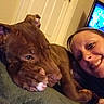 dog, woman, selfie, portrait, smiling, brown_dog, close_up, indoors, couch, blanket, television, door, heart_shaped_handle, pet, human, cuddling, relaxed, cozy, brown_fur, living_room