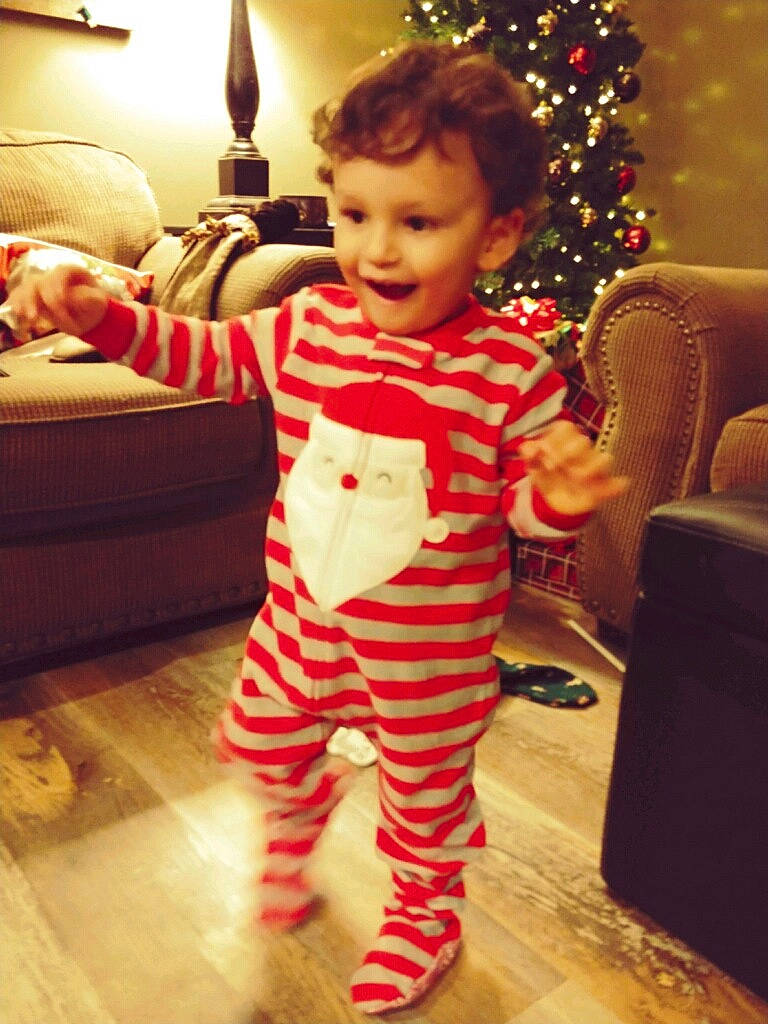 Jaylon is registered to the contest to win money with this photo: baby, child, christmas, christmas_decoration, christmas_eve, christmas_tree, head, holiday, nightwear, pajamas, person, sleeve, smile, standing, toddler