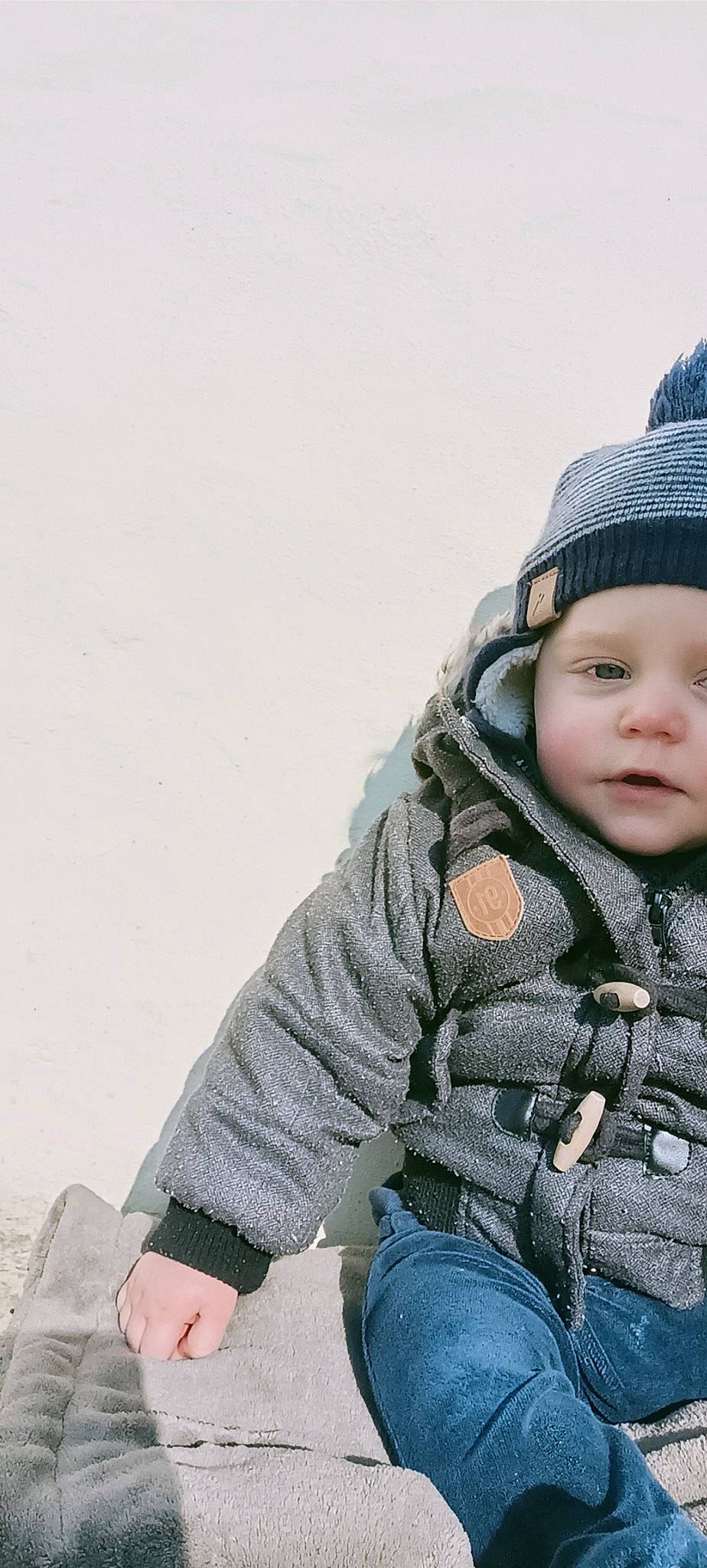 Kenzo participe au concours pour gagner de l'argent avec cette photo : baby, baby_toddler_clothing, beanie, cap, cheek, child, clothing, comfort, denim, electric_blue, freezing, fur, happy, headwear, jeans, pattern, person, sitting, sleeve, street_fashion