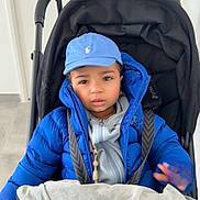 Elyes a rejoint le concours — aidez-le/la à gagner de superbes lots ! baby_boy, blanket, blue_cap, blue_jacket, child, cute, door, expression, hand, harness, hat, indoor, portrait, pram, puffy_jacket, seatbelt, stroller, tiled_floor, toddler, winter_clothing