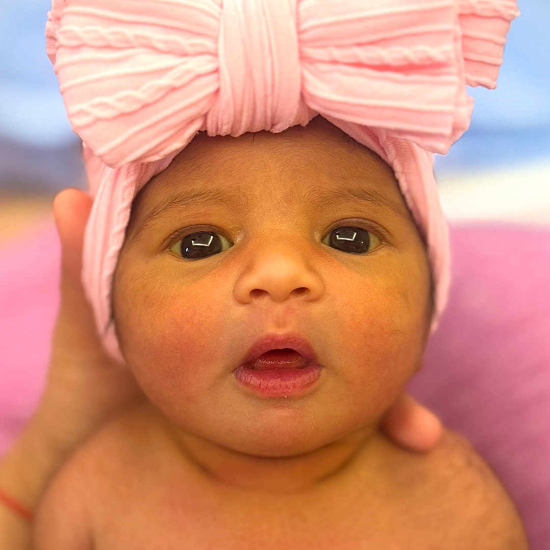 Aurora joined the competition — help win amazing prizes! baby, child, closeup, cute, expression, face, hand, headband, headwear, human, indoors, infant, looking_at_camera, newborn, person, pink_bow, portrait, skin, soft_light, warm_colors