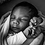 Djamaïly participe au concours pour gagner de l'argent avec cette photo : baby, sleeping, blanket, hands, face, infant, closeup, black_and_white, peaceful, soft, portrait, newborn, cute, wrapped, resting, cozy, child, toddler, calm, quiet