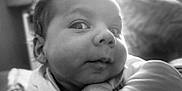 Djamaïly participe au concours pour gagner de l'argent avec cette photo : baby, infant, face, closeup, black_and_white, curious, expression, hand, arm, portrait, resting, soft_light, indoors, blurred_background, child, young, cute, person, skin, casual