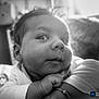 baby, infant, face, closeup, black_and_white, curious, expression, hand, arm, portrait, resting, soft_light, indoors, blurred_background, child, young, cute, person, skin, casual