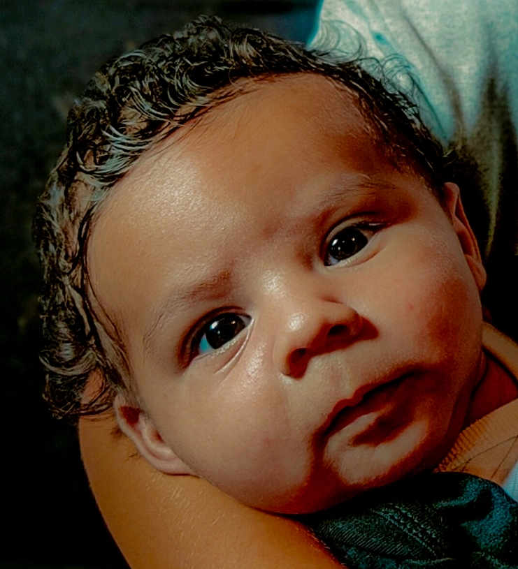 Djamaïly participe au concours pour gagner de l'argent avec cette photo : baby, child, face, curly_hair, eyes, skin, person, portrait, closeup, infant, expression, holding, arm, cute, young, head, human, looking, indoors, warm_light