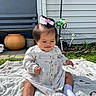 Giselle is registered to the contest to win money with this photo: baby, child, girl, outdoor, blanket, grass, bench, planter, socks, dress, hair_bow, smiling, garden, sunny, face, person, yard, plants, toy, pole
