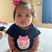 Giselle joined the competition — help win amazing prizes! baby, child, infant, sitting, bed, pink_bow, black_shirt, skull_design, heart_eyes, red_sock, white_pants, indoors, calendar, curtains, soft_lighting, cute, portrait, young_child, hands, face
