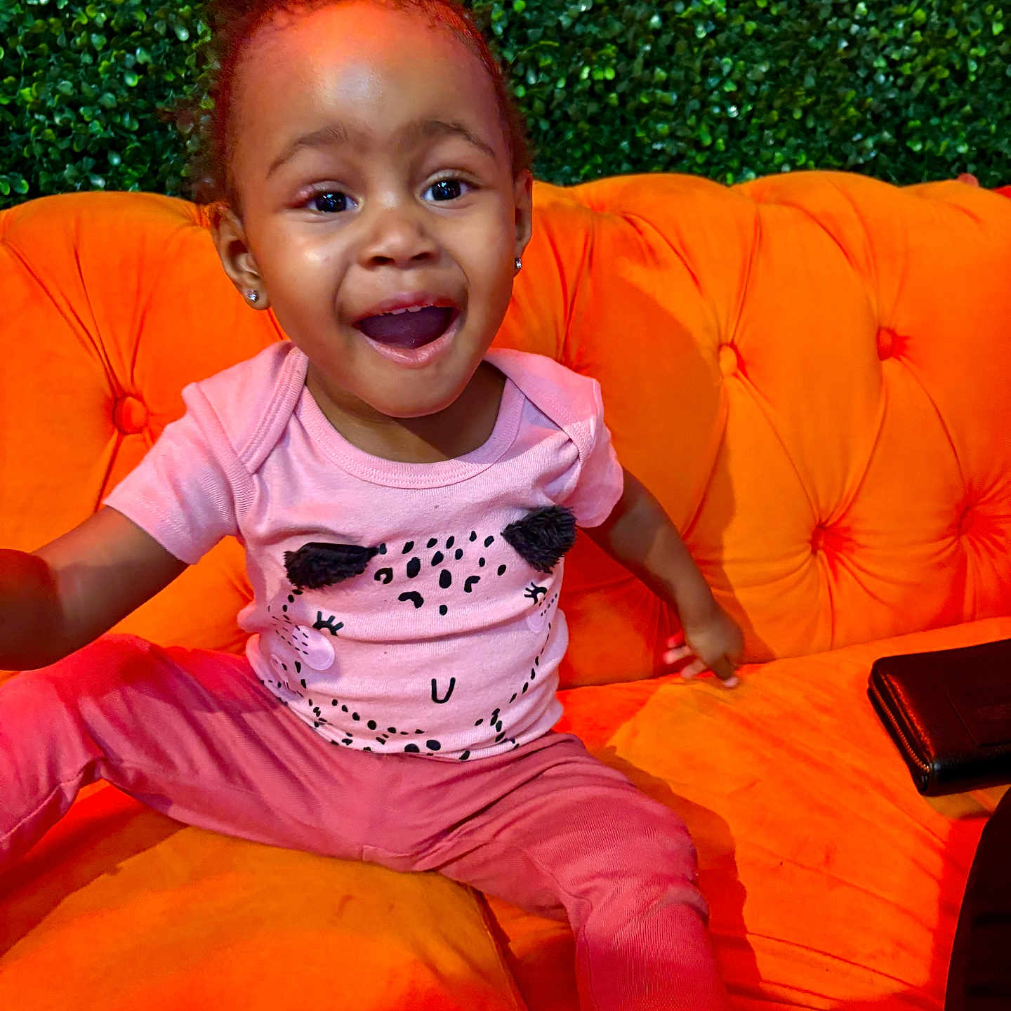 Raea is registered to the contest to win money with this photo: accessories, child, clothing, couch, cushion, face, female, footwear, furniture, girl, happy, head, homedecor, person, photography, portrait, shoe, sitting, t_shirt, wallet