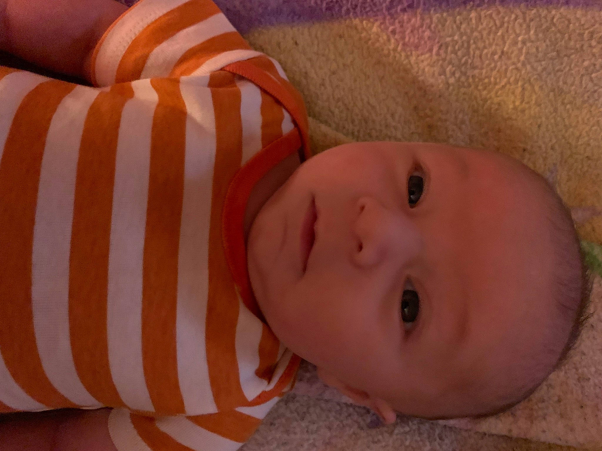 Jake is registered to the contest to win money with this photo: baby, baby_toddler_clothing, cheek, child, close_up, comfort, flooring, fun, hair, human_body, human_leg, linens, lip, mouth, nose, pattern, person, skin, smile, toddler