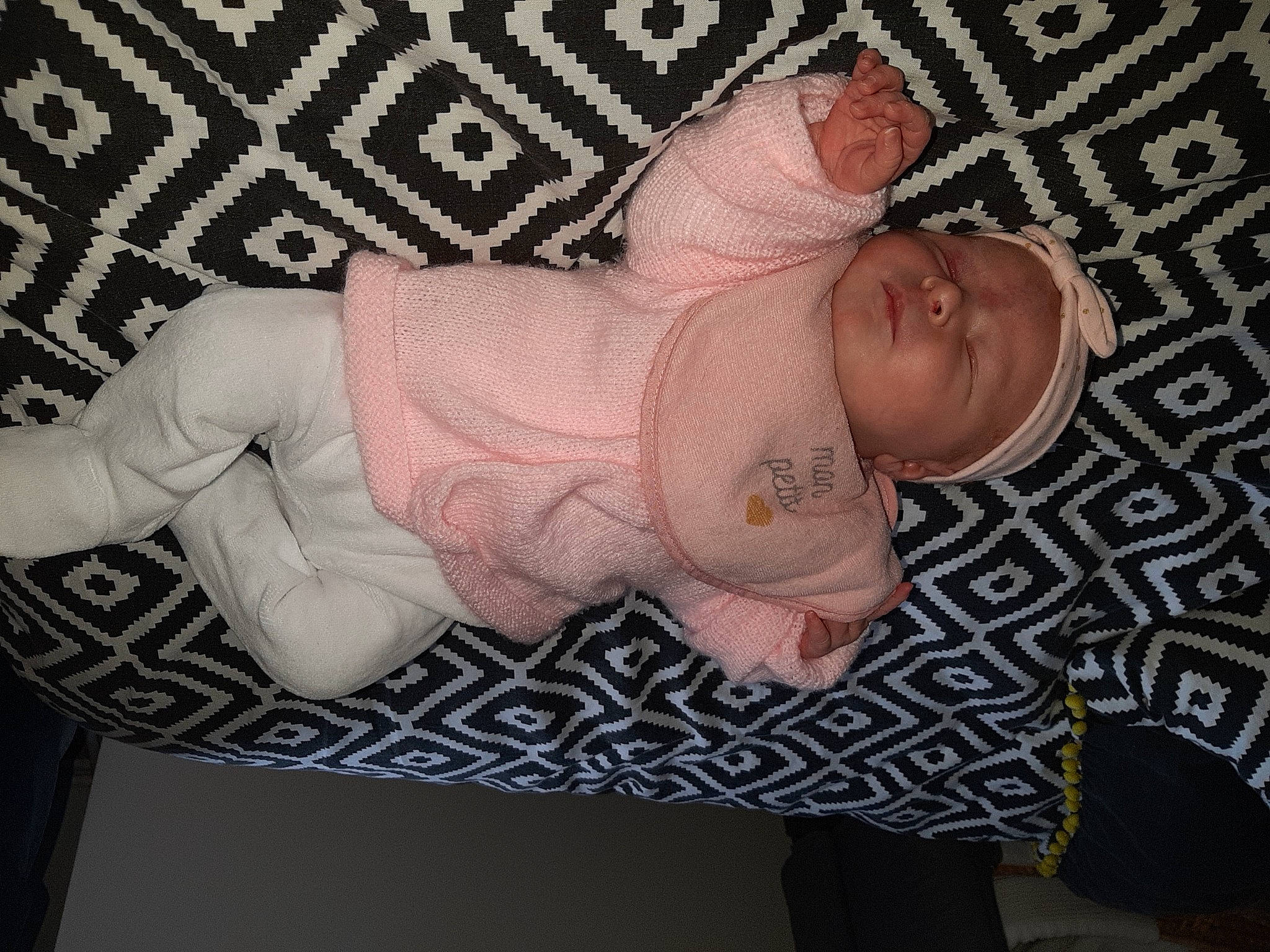 Clara participe au concours pour gagner de l'argent avec cette photo : arm, baby, baby_products, baby_toddler_clothing, cheek, child, comfort, finger, foot, head, headgear, human_body, leg, nail, pattern, person, pink, sleeve, textile, thumb