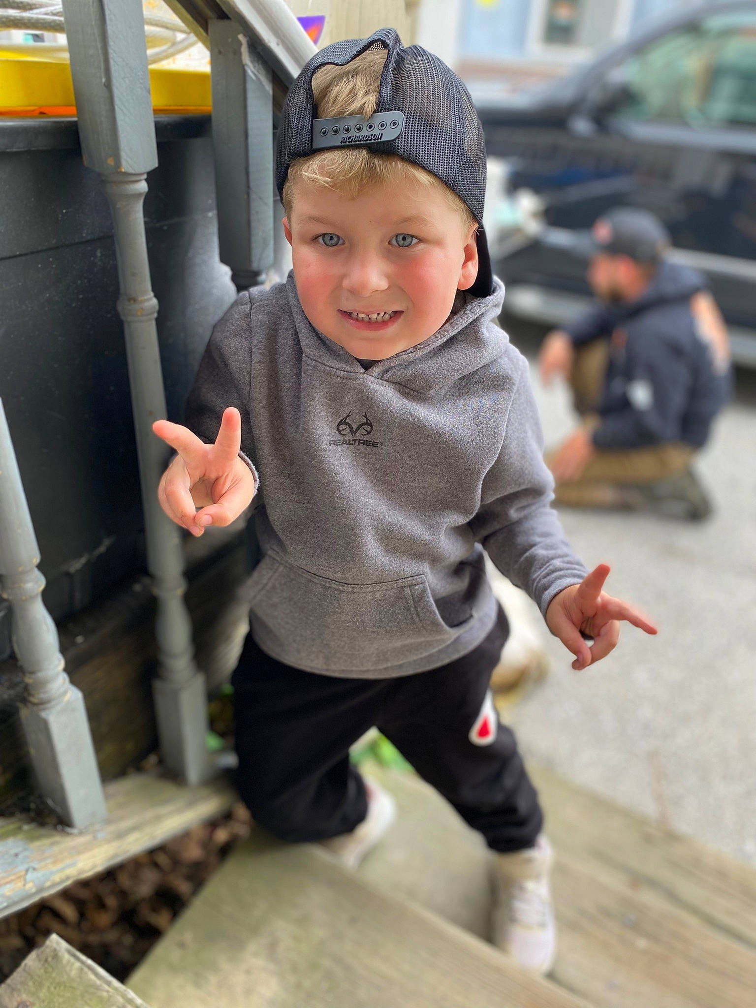 Kye is registered to the contest to win money with this photo: baby, baby_toddler_clothing, baseball_cap, cap, child, city, flooring, fun, happy, hat, headwear, joy, leisure, person, recreation, sitting, sleeve, smile, sportswear, t_shirt
