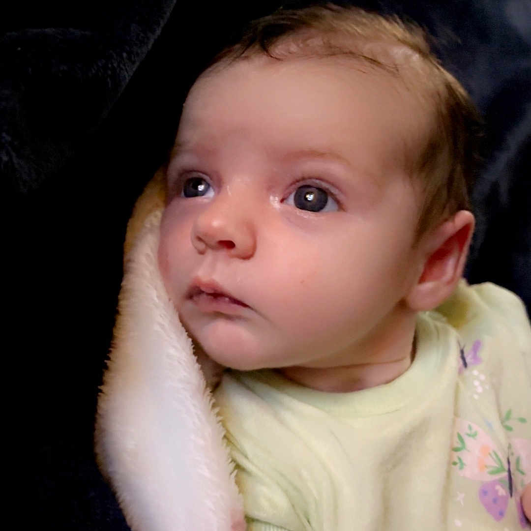 Everleigh is registered to the contest to win money with this photo: baby, blanket, bodypart, bonnet, clothing, face, finger, frown, hand, happy, hat, head, mouth, newborn, person, photography, portrait, sad, smile, t_shirt