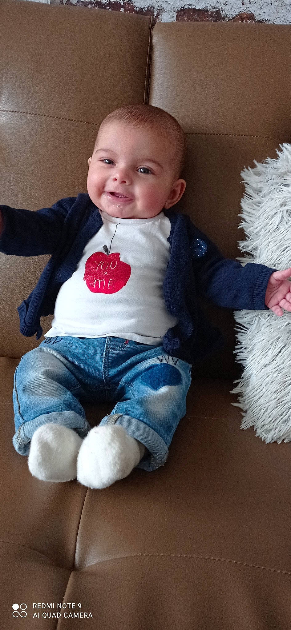 Nalya participe au concours pour gagner de l'argent avec cette photo : arm, baby, baby_toddler_clothing, cheek, child, comfort, face, finger, flash_photography, happy, joy, knee, leg, person, sitting, skin, sleeve, smile, t_shirt, textile