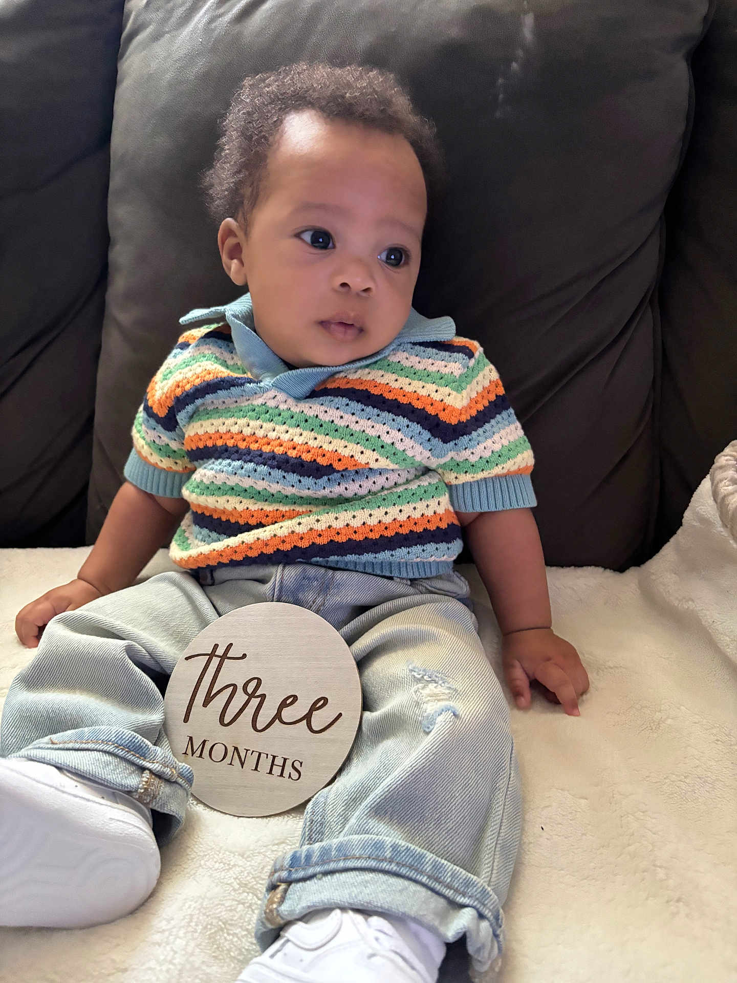 Kairo joined the competition — help win amazing prizes! baby, infant, child, three_months, sitting, striped_sweater, denim_jeans, white_shoes, blanket, couch, wooden_sign, milestone, curly_hair, indoor, portrait, cute, soft_lighting, casual_clothing, young_child, comfortable