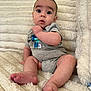 Rory is registered to the contest to win money with this photo: baby, infant, child, sitting, gray_onesie, blanket, fluffy, indoor, curious, wide_eyes, soft_texture, cute, portrait, young_child, barefoot, small_hands, expression, comfort, cozy, home