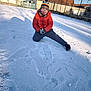 Owen participe au concours pour gagner de l'argent avec cette photo : child, snow, winter_clothing, hat, glasses, orange_jacket, playing, outdoor, snowy_ground, scarf, smiling, fence, houses, footwear, daylight, blue_sky, cold_weather, pose, gloves, fun