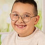 Owen a rejoint le concours — aidez-le/la à gagner de superbes lots ! child, boy, smile, glasses, short_hair, missing_tooth, beige_sweater, portrait, indoors, face, happy, casual_clothing, head_and_shoulders, window_background, young_person, light_skin, eyewear, closeup, studio_lighting, child_portrait