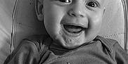 Nolan participe au concours pour gagner de l'argent avec cette photo : baby, smiling, drool, face, head, clothing, shirt, bicycle_illustration, text, black_and_white, portrait, infant, cute, happy, indoor, seated, closeup, child, person, comfortable