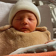 Milo a rejoint le concours — aidez-le/la à gagner de superbes lots ! newborn, baby, infant, sleeping, hat, beanie, swaddled, blanket, bassinet, hospital, cozy, portrait, close_up, peaceful, face, skin, nursery, bedding, soft_texture, blanket_orange