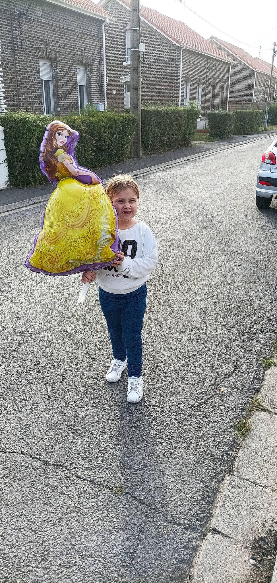 Angelina a rejoint le concours — aidez-le/la à gagner de superbes lots ! asphalt, automotive_exterior, automotive_tire, car, gesture, grass, jeans, leisure, motor_vehicle, pedestrian, person, personal_luxury_car, plant, recreation, road, road_surface, sidewalk, street, toddler, vehicle_door