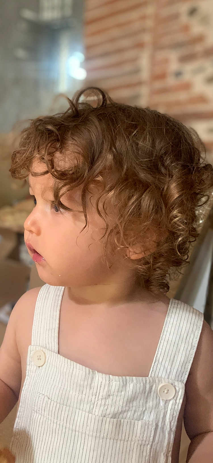 Achille a rejoint le concours — aidez-le/la à gagner de superbes lots ! toddler, child, curly_hair, profile, overalls, striped_clothing, indoor, soft_light, portrait, young_child, face, skin, button, hair, person, cute, looking_away, casual, childhood, baby