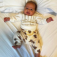 Ethan joined the competition — help win amazing prizes! baby, infant, child, portrait, lying_down, bed, pillow, white_bedding, sweater, pajamas, teddy_bears, clothing, face, eyes, smiling, arms_outstretched, bare_feet, indoor, cozy, photography