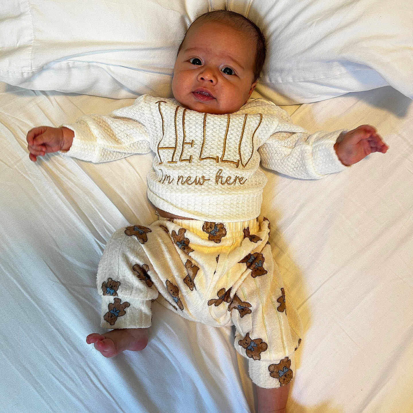 Ethan joined the competition — help win amazing prizes! baby, infant, child, portrait, lying_down, bed, pillow, white_bedding, sweater, pajamas, teddy_bears, clothing, face, eyes, smiling, arms_outstretched, bare_feet, indoor, cozy, photography