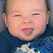 Stetson joined the competition — help win amazing prizes! baby, infant, child, face, smile, tongue_out, cheeks, eyes, head, hair, skin, blanket, knitted_blanket, blue_blanket, clothing, car_seat, seat, portrait, close_up, cozy