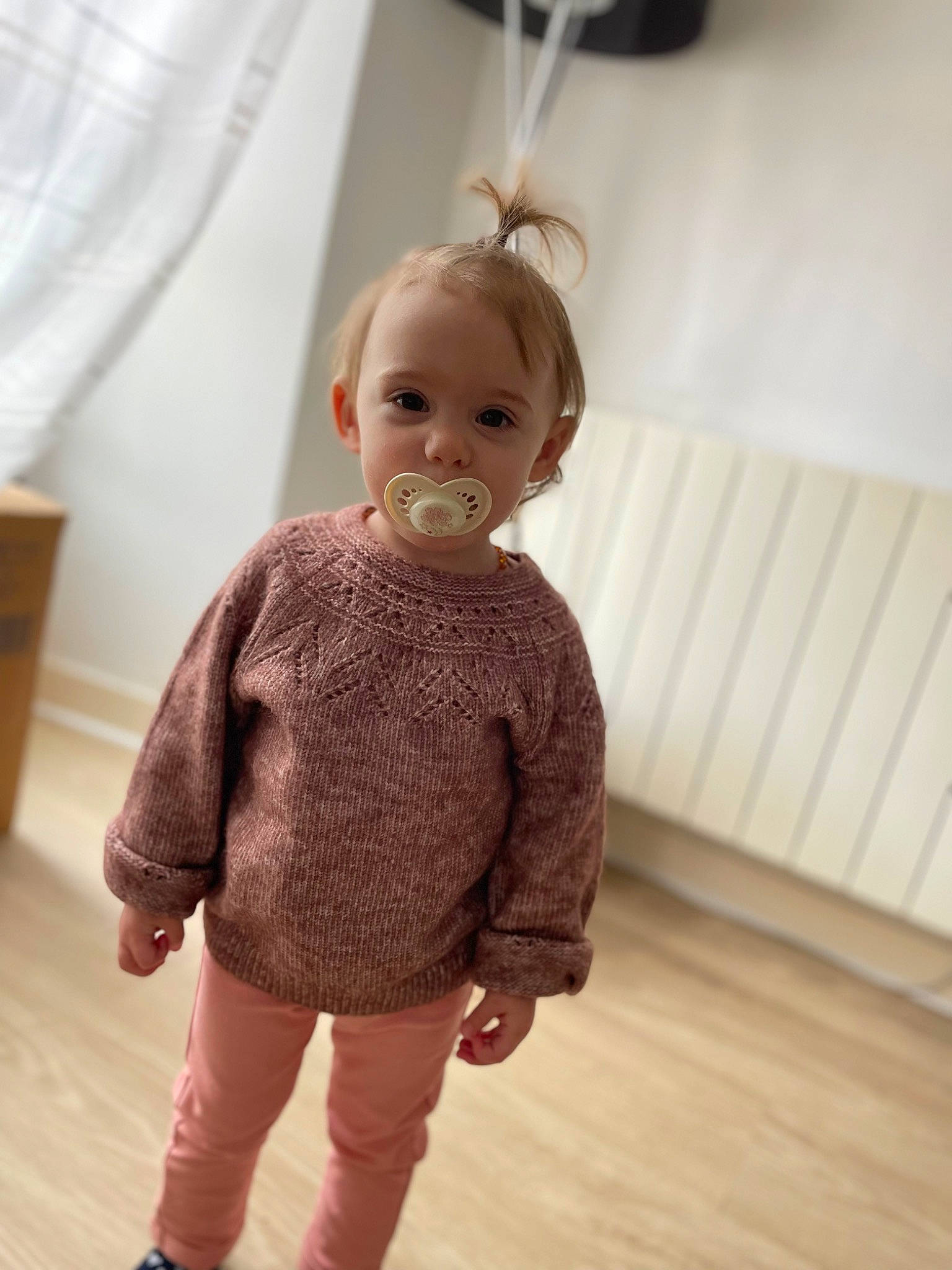 Mia participe au concours pour gagner de l'argent avec cette photo : baby_toddler_clothing, blond, child, eyelash, fashion_accessory, fashion_design, floor, flooring, hardwood, joint, neck, outerwear, person, shoulder, skin, sleeve, standing, toy, waist, wood