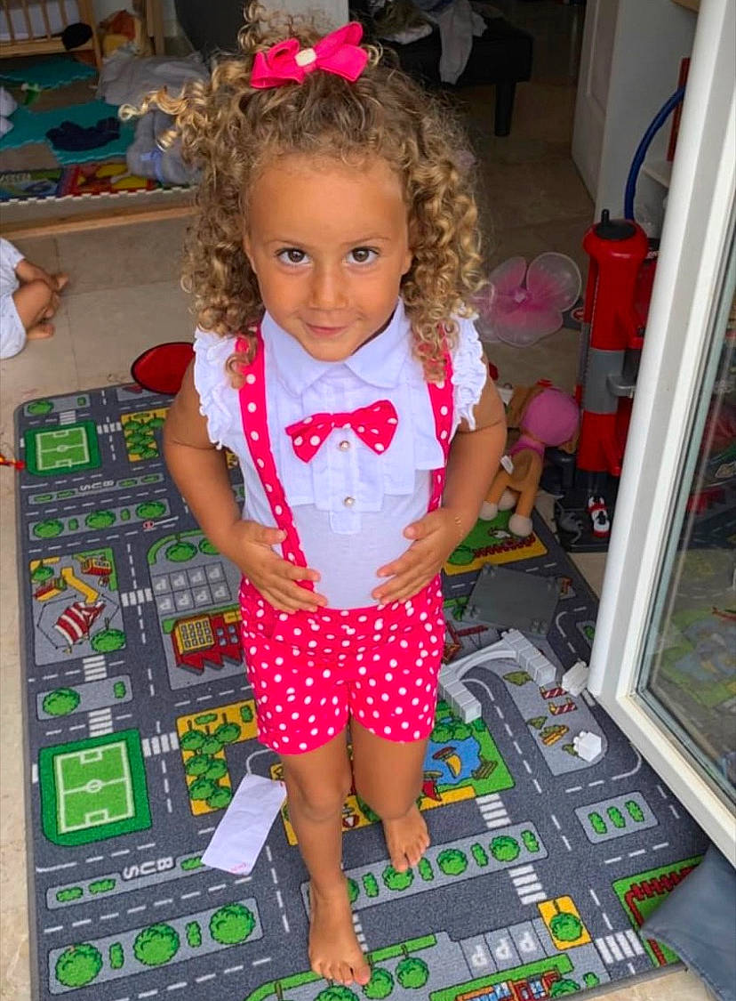 Talya participe au concours pour gagner de l'argent avec cette photo : baby_toddler_clothing, chair, child, event, flooring, fun, human_leg, joy, leisure, magenta, party, pattern, person, pink, play, polka_dot, room, sandal, shorts, sitting
