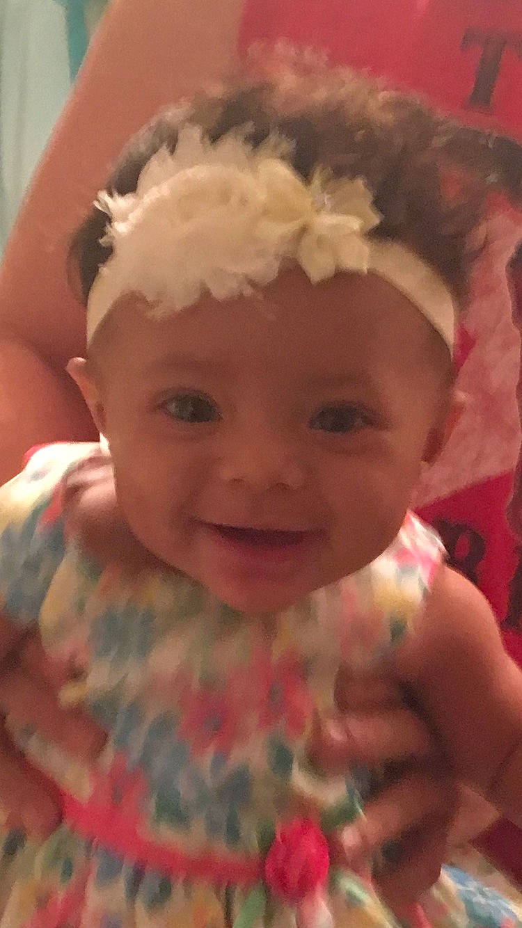 Alexandria is registered to the contest to win money with this photo: cheek, child, eye, eyebrow, face, forehead, girl, hair_accessory, head, headband, headgear, human_hair_color, infant, iris, lip, mouth, nose, person, pink, skin