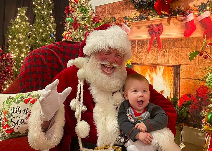 Beau is registered to the contest to win money with this photo: beard, christmas, christmas_decoration, christmas_tree, event, fun, green, happy, hat, headwear, holiday, lap, person, photograph, plant, red, santa_claus, smile, snapshot, tradition