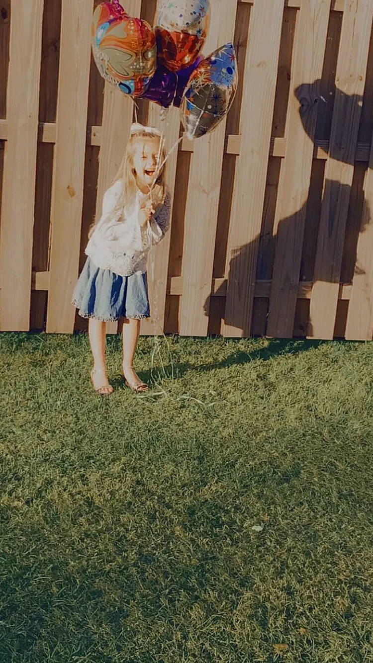 Maci is registered to the contest to win money with this photo: blond, child, denim, dress, electric_blue, event, fashion_design, flag, fun, grass, happy, human_leg, leisure, person, plant, recreation, sandal, sitting, toddler, vintage_clothing