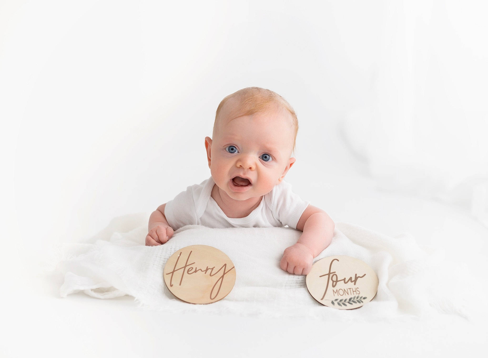 Henry is registered to the contest to win money with this photo: baby, baby_toddler_clothing, cheek, child, collectable, comfort, eye, face, flash_photography, font, foot, gesture, happy, linens, person, portrait_photography, sitting, smile, surprise, thumb